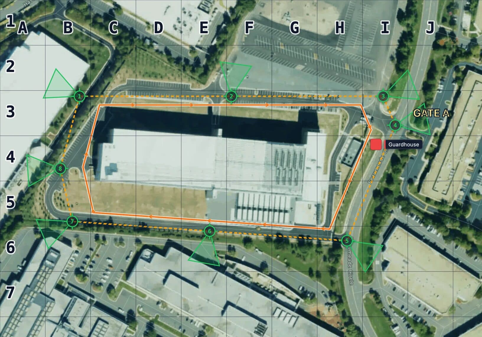 Corporate site security plan map on satellite imagery in MapGridder: a dashed amber fence line around a large single building, eight numbered green camera posts on the fence with green coverage wedges facing outward, an orange patrol route with direction arrows inside the fence, a Guardhouse marker and a GATE A label, all under a lettered and numbered 50 meter grid.